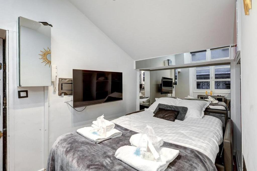 a bedroom with a large bed with towels on it at Paris Marais Tiny MERRISAS in Paris