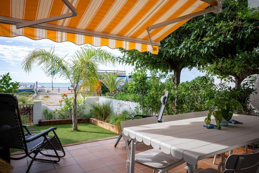 a patio with a table and chairs and a view of the ocean at AT153 First line of the beach in Creixell