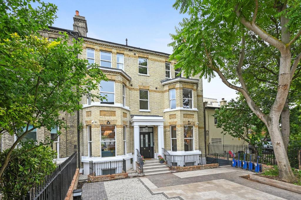 una vista exterior de una casa de ladrillo con árboles en Nightingale Suites, en Londres