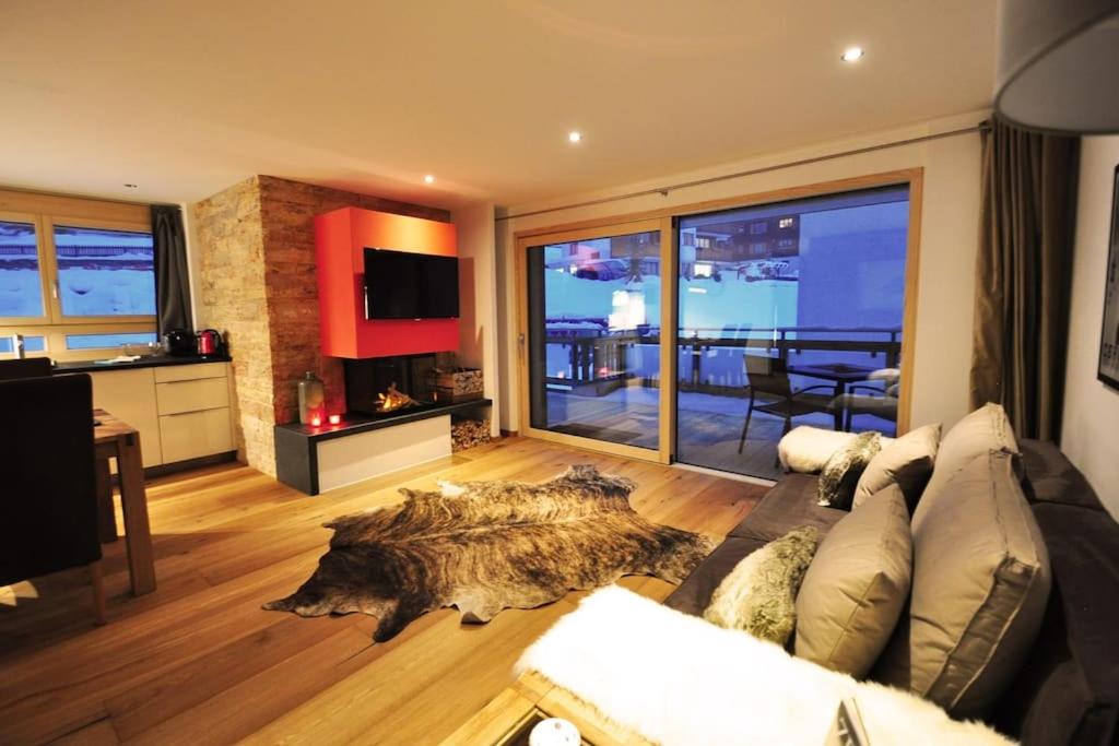 a living room with a couch and a table and a kitchen at Comfort apartment in Zermatt