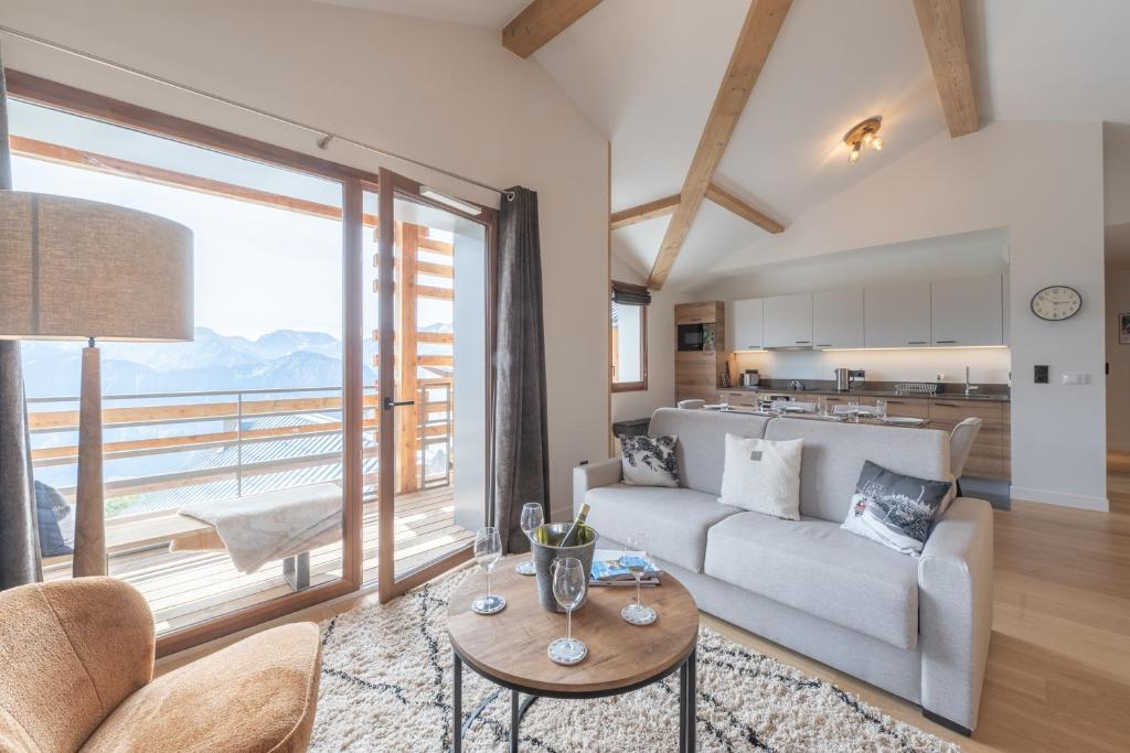 ein Wohnzimmer mit Sofa und Tisch in der Unterkunft Alpe d'Huez Houses - Chez Emma - Fermes de l'Alpe - du cachet dans le vieil Alpe in L'Alpe-d'Huez