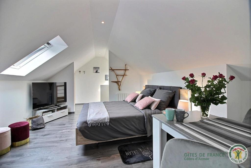 une chambre avec un lit et une télévision à écran plat dans l'établissement Le domaine de kermel, à Pleubian