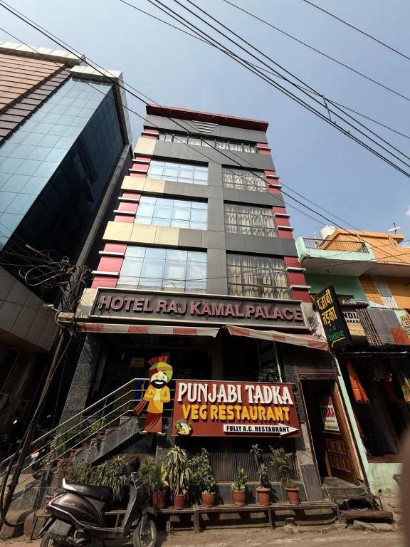 Un edificio alto con un cartel delante. en Raj Kamal Hotel Near Temple With Lift, en Varanasi