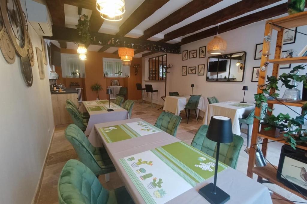 a restaurant with white tables and green chairs at DORDOGNE 24 Chambre d'hôtes Jardin d'hiver Élégance Champêtre pour un séjour in Rouffignac Saint-Cernin