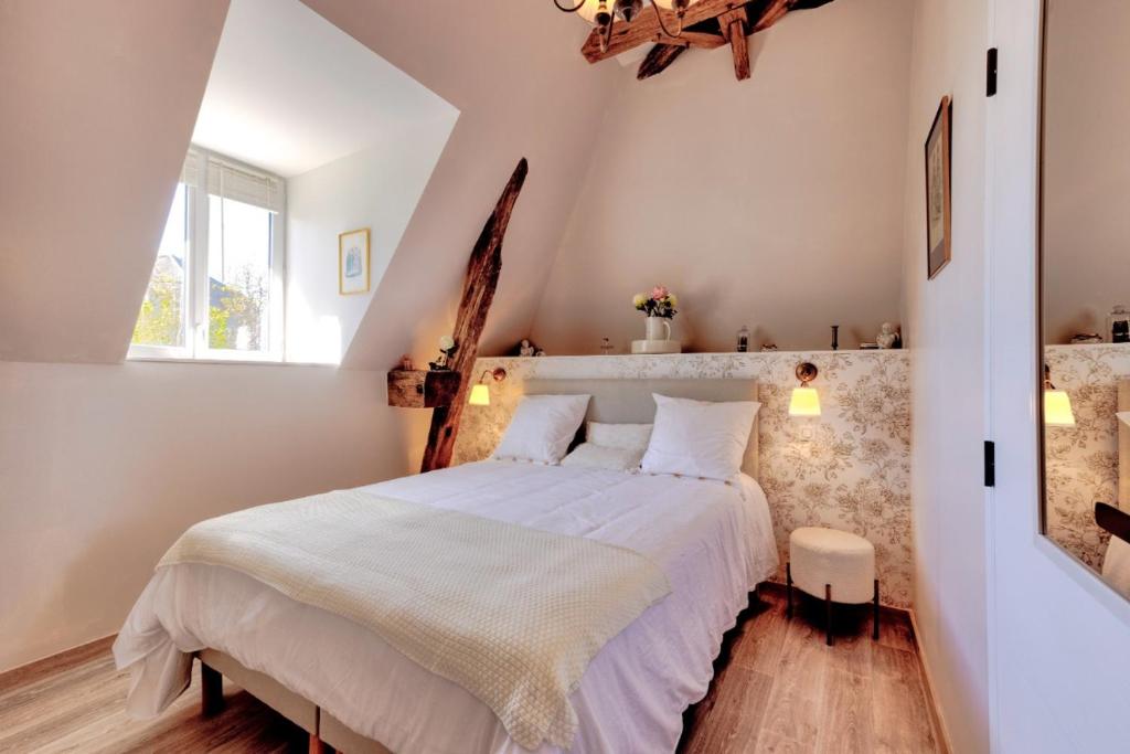 a bedroom with a large bed in a attic at DORDOGNE 24 Chambre d'hôtes Romantique Élégance et Charme avec piscine au coeur du Périgord in Rouffignac Saint-Cernin