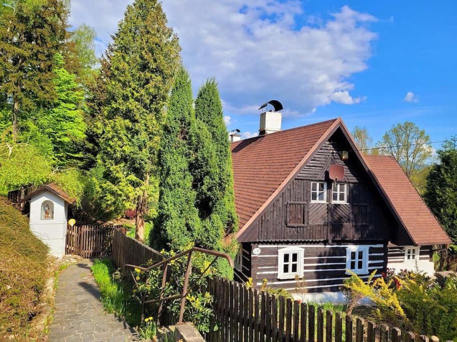 una casa in legno con una recinzione accanto ad essa di Roubenka u kapličky a Liberec