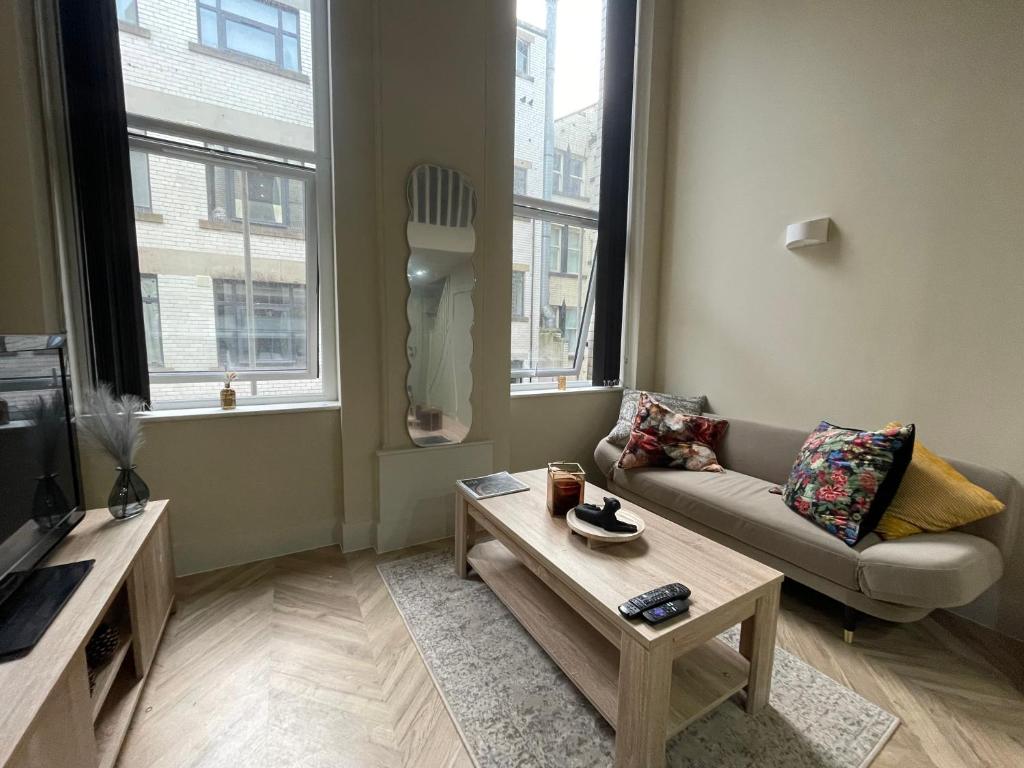 a living room with a couch and a coffee table at Stylish Mezzanine Apartment In Central Leeds in Central Station