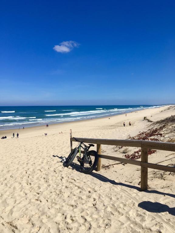 a bike parked on a beach next to a fence at Residence Plage Oceane in Biscarrosse-Plage