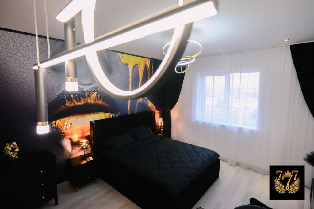 a bedroom with a black bed and a painting on the wall at FLH - 777 Apartments in Bucharest