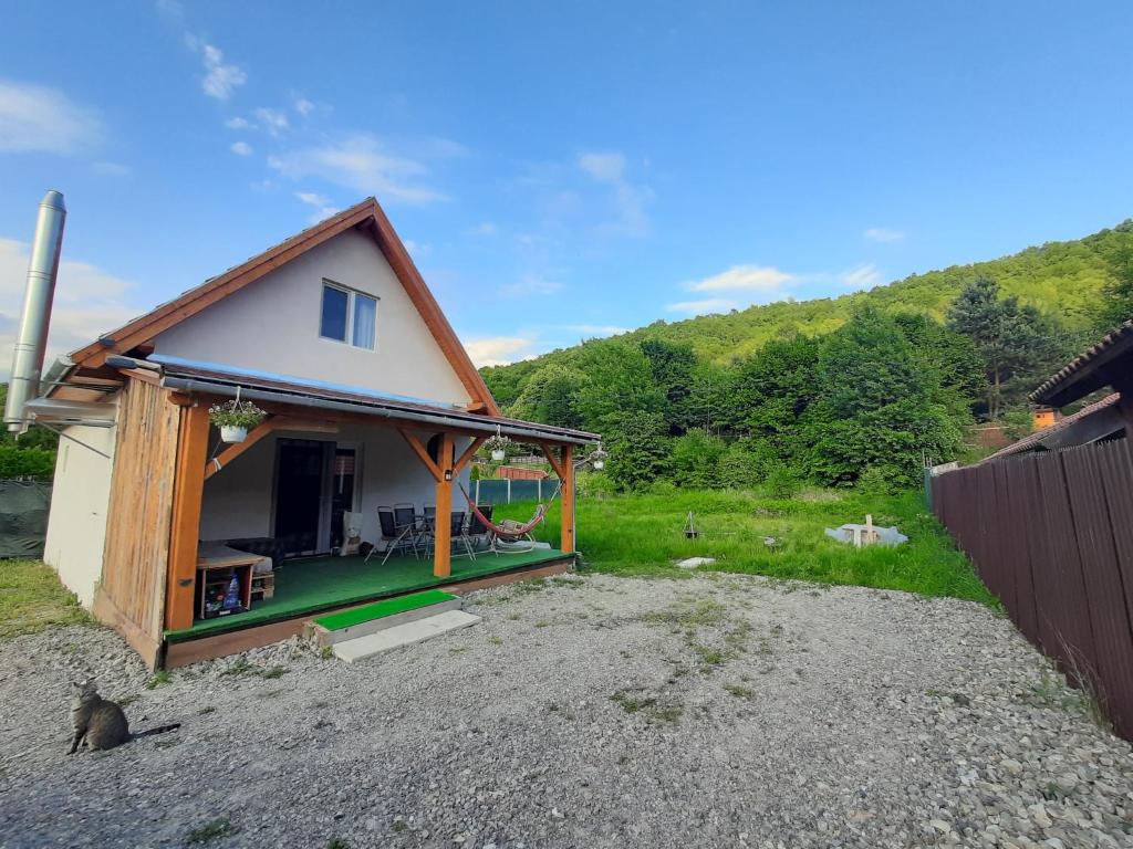 a small house sitting on top of a gravel lot at Mountain Cozy Home in Sub Cetate