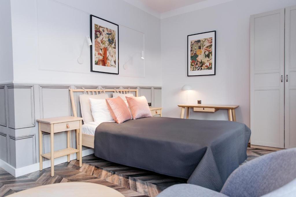a bedroom with a bed and two tables at Neptunus MB By the Ses Apartments OLD TOWN in Gdańsk