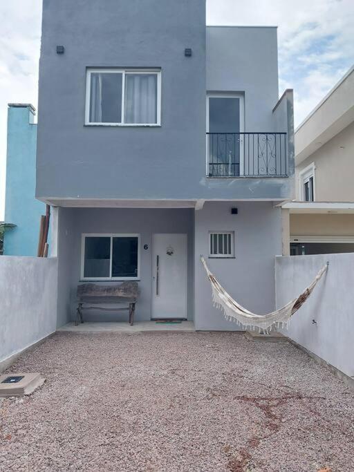 una casa bianca con un'amaca di fronte di Sobrado Novo 3 quartos a São Lourenço do Sul