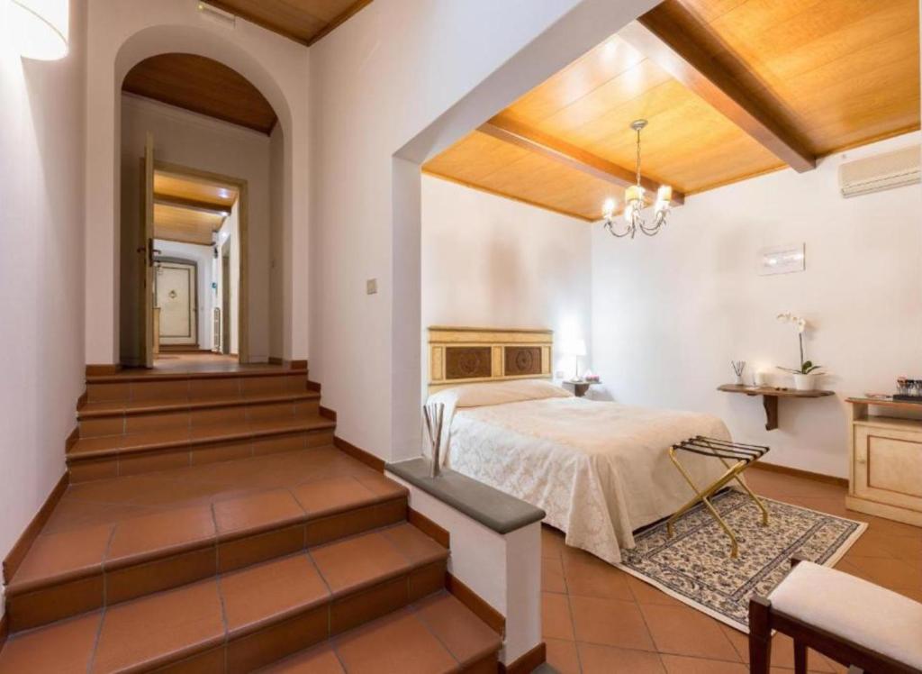 sypialnia z łóżkiem w pokoju ze schodami w obiekcie Numa Florence Palazzo Haggis we Florencji