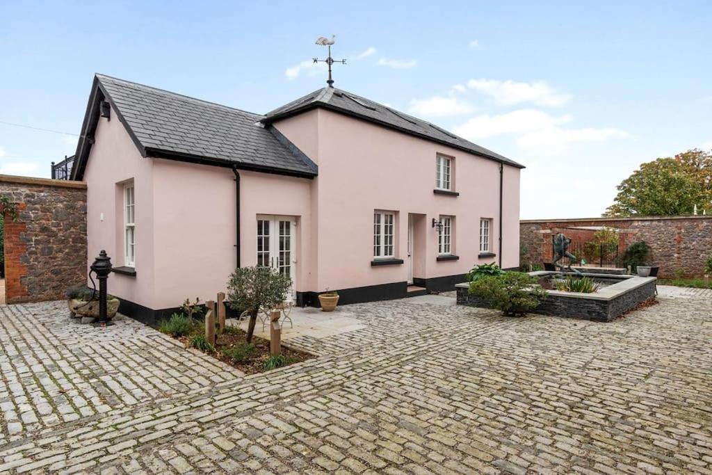 une église blanche avec une croix sur le toit dans l'établissement Coachmans Cottage, East Budleigh, Sleeps 6, à East Budleigh