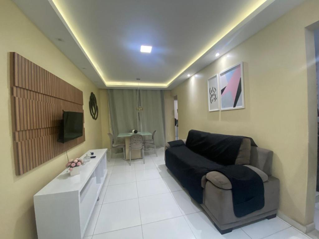 a living room with a couch and a tv at Apartamento A 700m da orla mais bonita do país no bairro Atalaia in Santa Maria