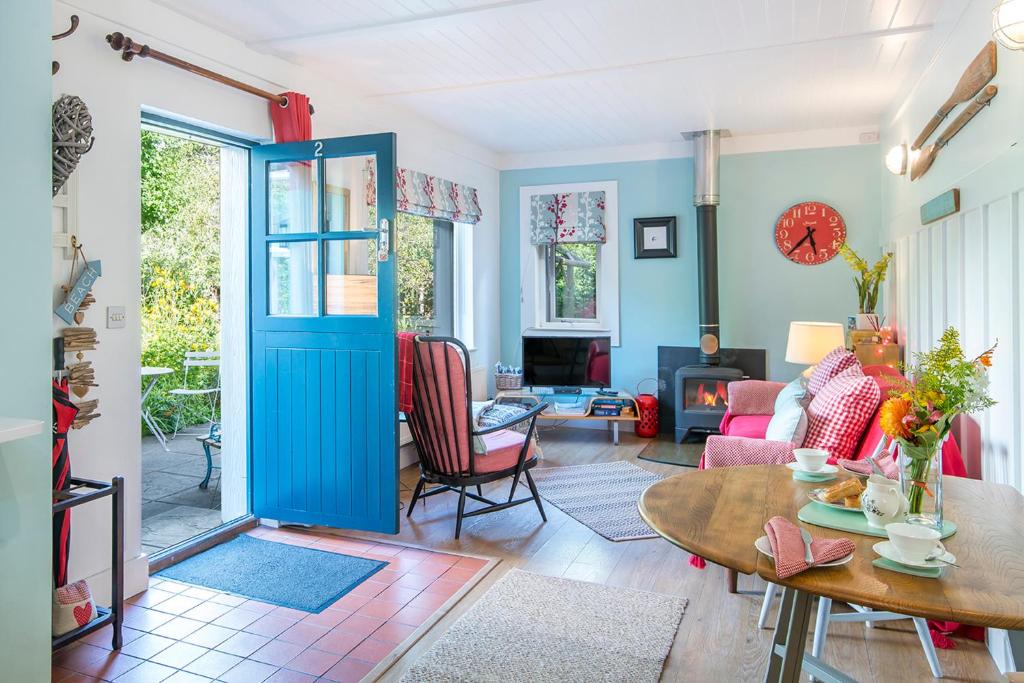 a living room with a blue door and a table at 2 Penally Boathouse Mews in Cardigan