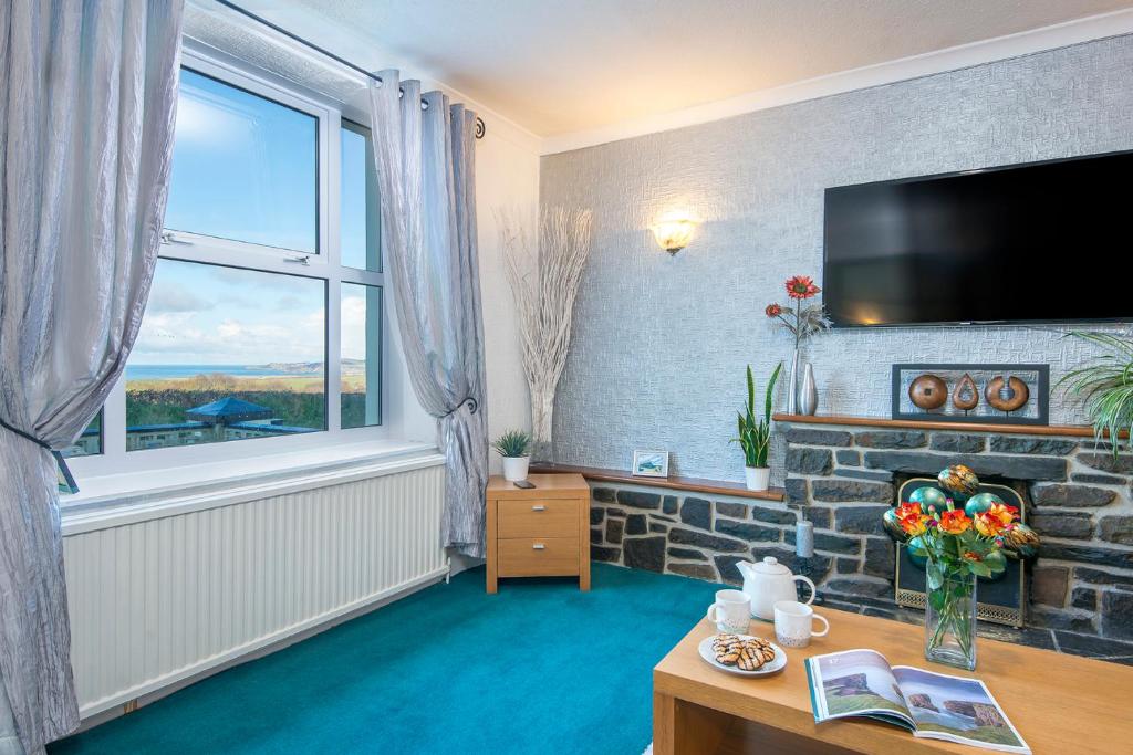 ein Wohnzimmer mit Kamin und Fernseher in der Unterkunft Llwyndyrys in Haverfordwest