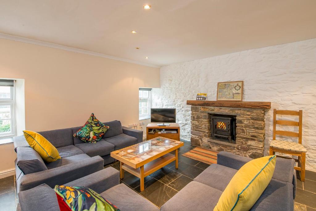 1 Grove Stables في سانت دافيدز: غرفة معيشة مع أريكة ومدفأة