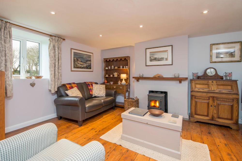 a living room with a couch and a fireplace at Drws Gobaith-West in Haverfordwest