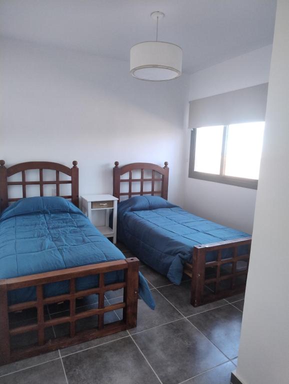 a bedroom with two beds and a window at Departamento Malbec House in Maipú