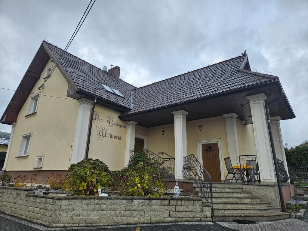 a yellow house with a black roof at Dom Noclegowy Wiktoria in Skrzyszów