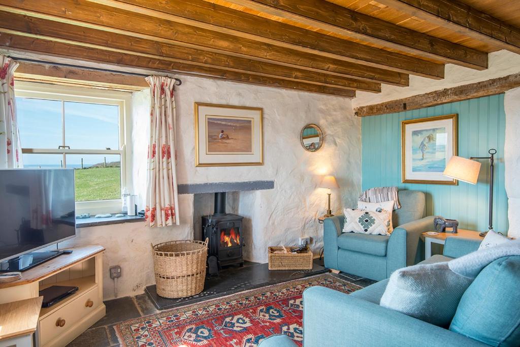 a living room with a blue couch and a fireplace at Lower Porthmawr in Haverfordwest