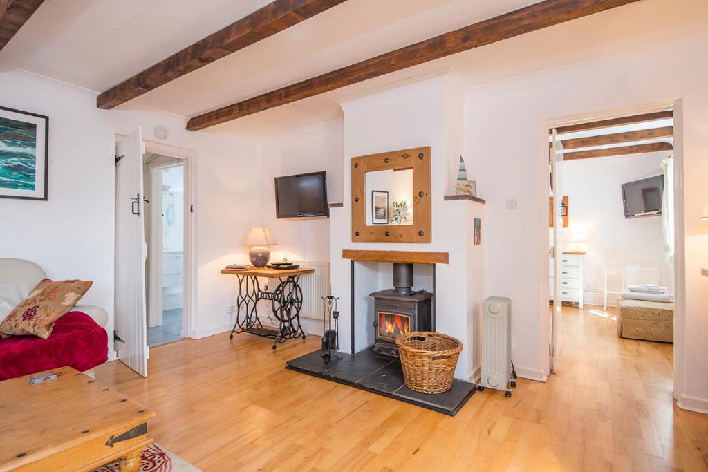 a living room with a fireplace and a red couch at Willowcot Cottage in Haverfordwest