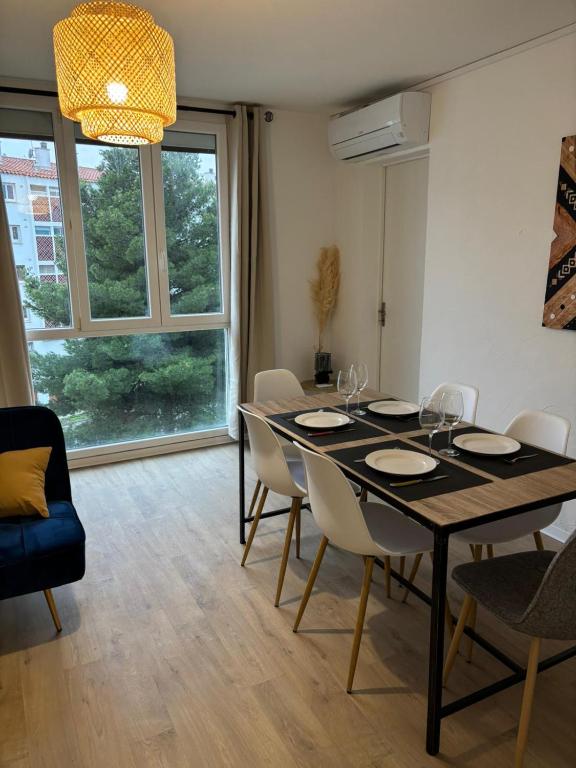 une salle à manger avec une table et des chaises noires dans l'établissement Appartement T4 Quartier Moulin à vent, à Perpignan