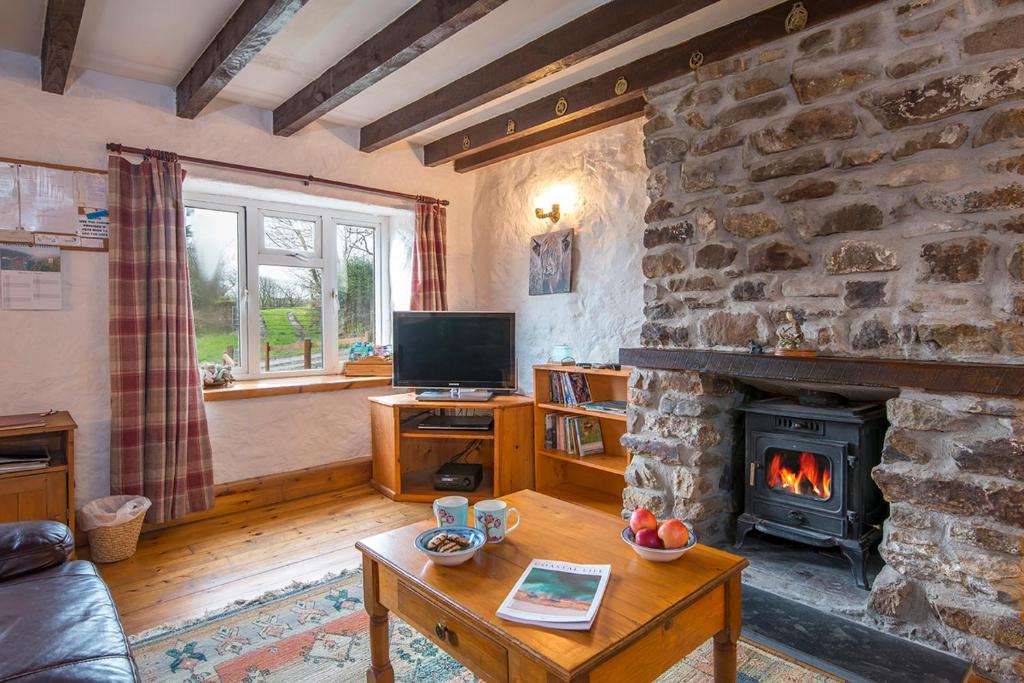 ein Wohnzimmer mit einer Steinmauer und einem Kamin in der Unterkunft Honey Hook Cottage in Haverfordwest