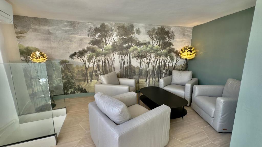 - un salon avec des chaises blanches et un tableau mural dans l'établissement Centre Historique Appartement Climatisé avec terrasse, à Aix-en-Provence