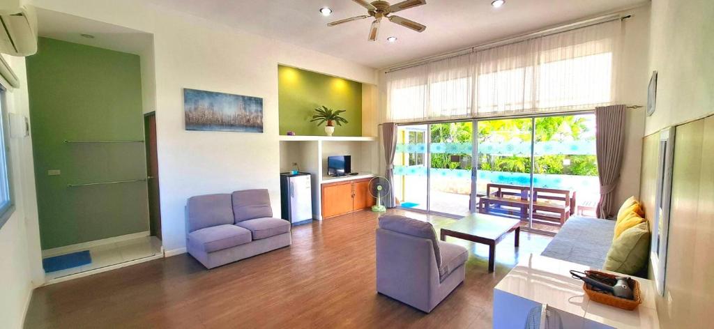 een woonkamer met een bank en een tafel bij บ้านพิม in Pran Buri