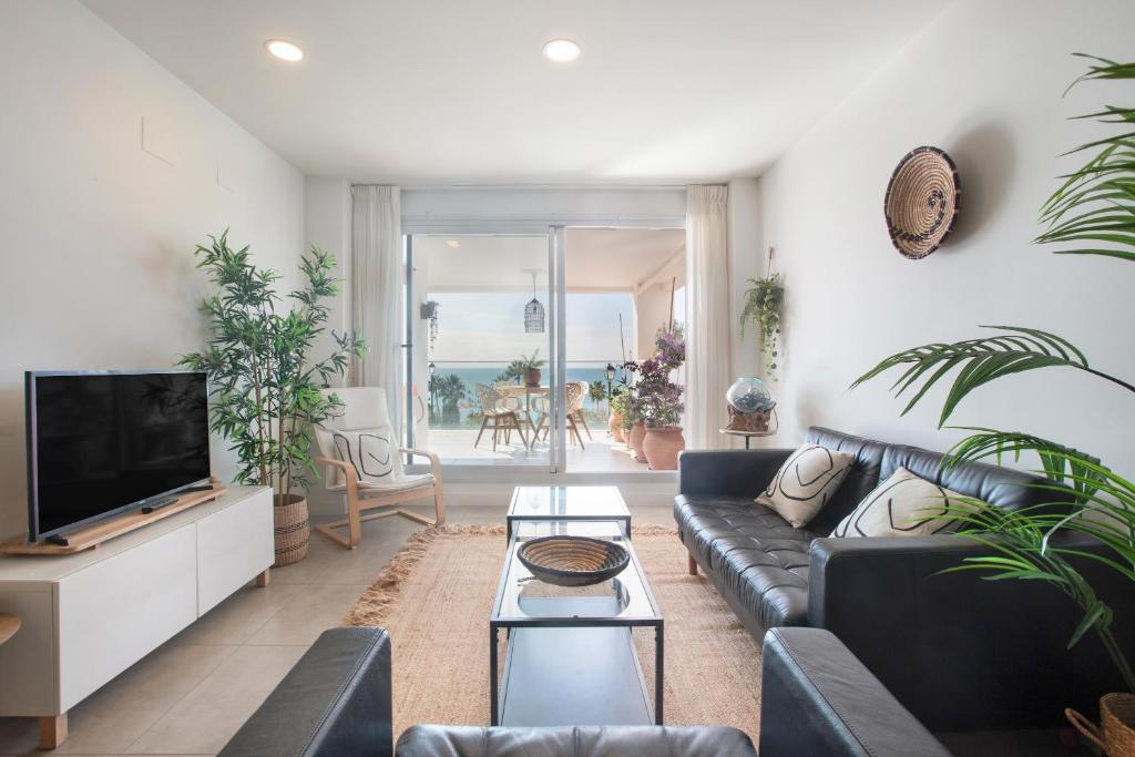 Una sala de estar con un sofá y un televisor. en Seaview apartment Alba, en Torrequebrada