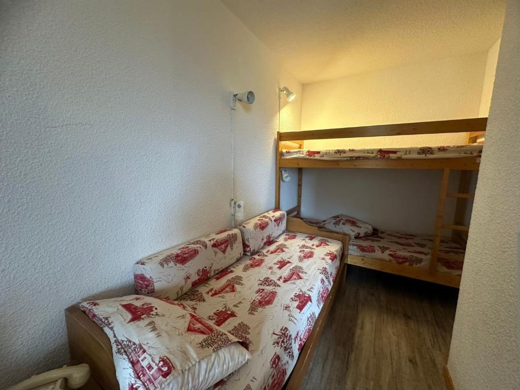 Cette petite chambre comprend un canapé et des lits superposés. dans l'établissement Studio divisible rénové, pied des pistes, balcon, 4 pers., La Plagne - FR-1-181-1104, à Plagne Bellecôte