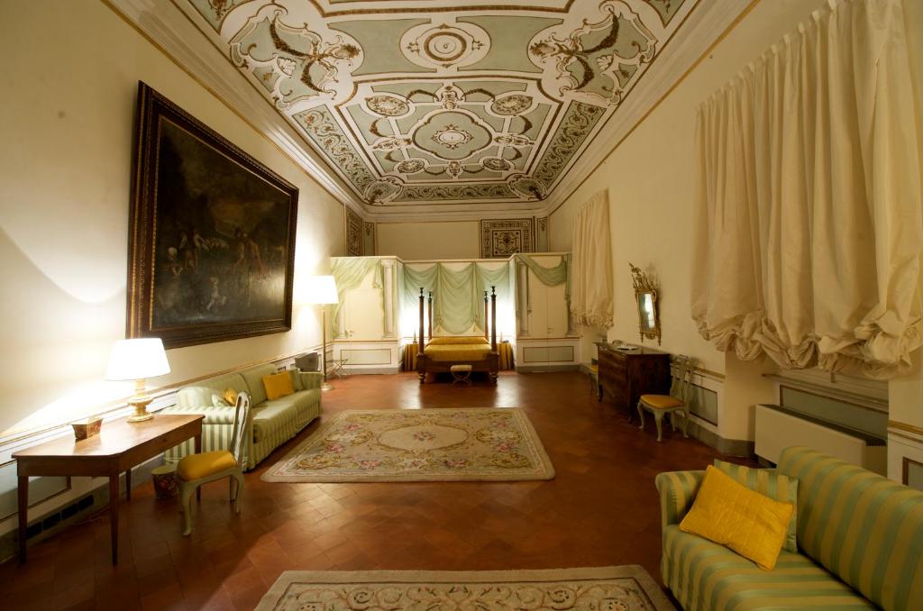 ein Wohnzimmer mit einem Sofa und einem Tisch in der Unterkunft Palazzo Tucci Residenza d'epoca in Lucca