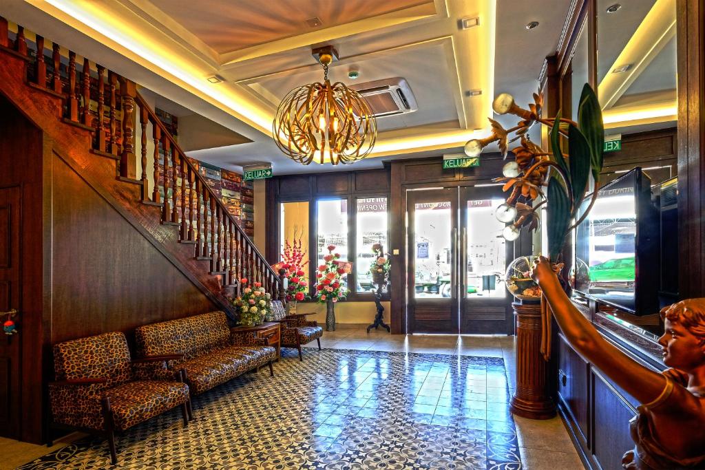 a lobby with a staircase and chairs and a chandelier at Island Guesthouse - Previously known as Islander Lodge in George Town