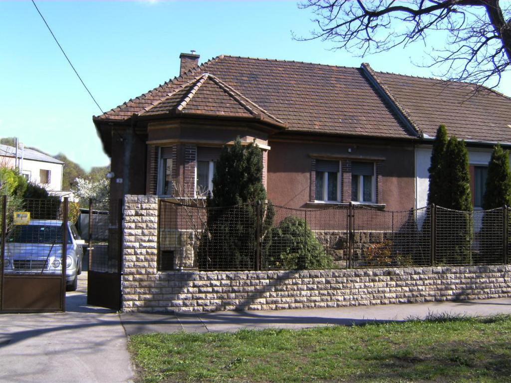 a brick house with a fence in front of it at Haus in Budapest mit Garten in Budapest