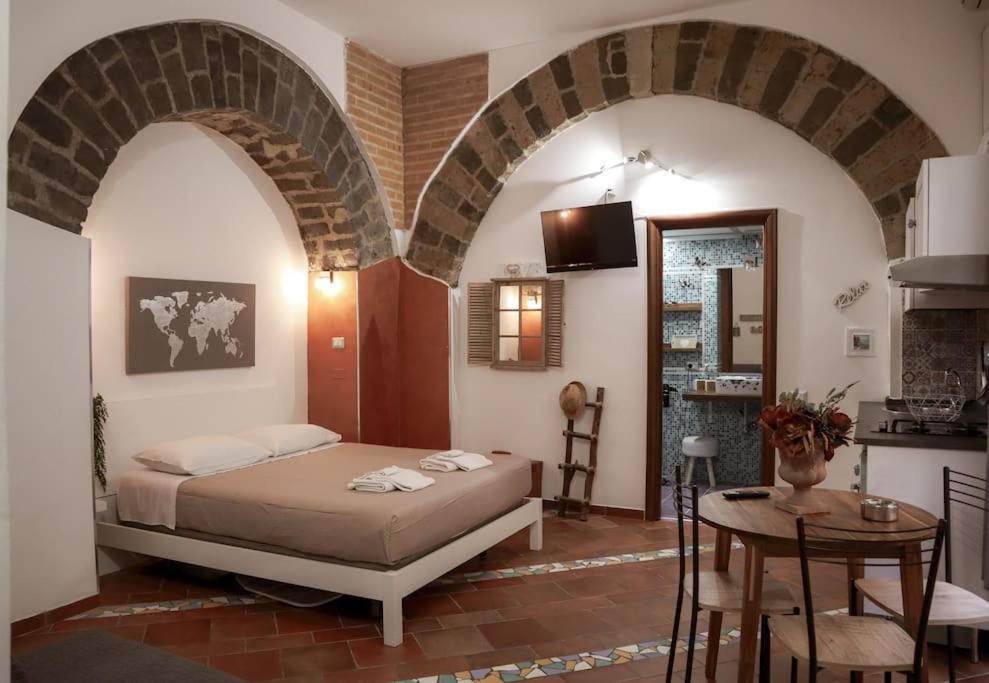 サレルノにあるIcon Livingのベッドとテーブルとキッチンのある寝室