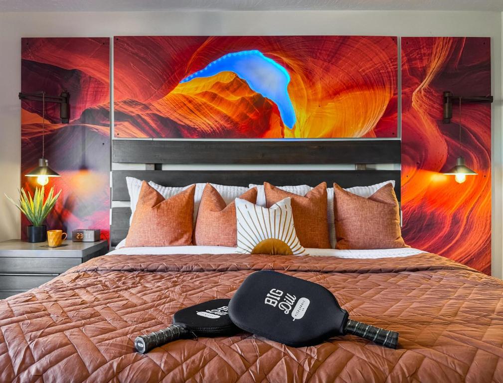 a bedroom with a bed with a painting on the wall at Stargazer – Luxury Condo, Rooftop Views, Private Hot Tub in St. George