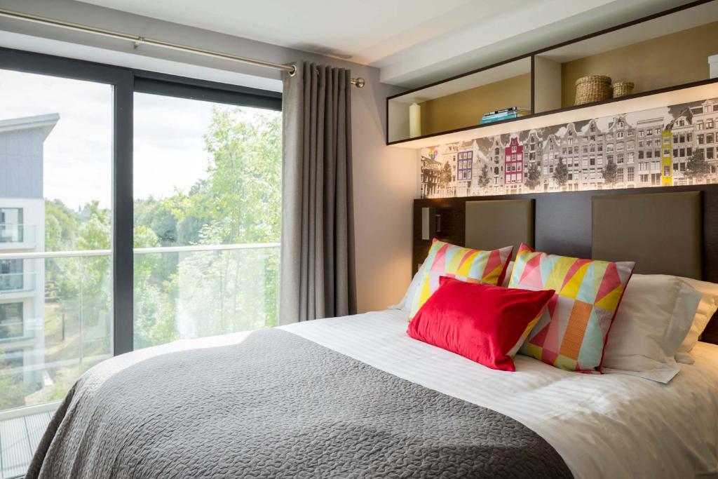 a bedroom with a bed with a large window at Comfortable Studio For 2 In Leeds with Free Grab&Go Breakfast in Headingley