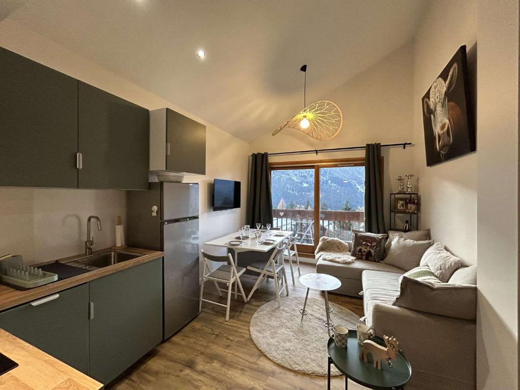 une cuisine et un salon avec un canapé et une table dans l'établissement Appartement 3 pièces avec Mezzanine, 5 pers, Méribel - Animaux admis, WiFi - FR-1-180-595, à Les Allues