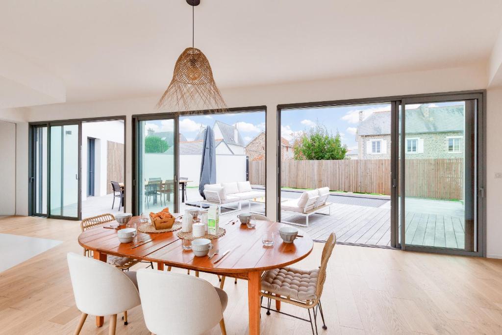 a dining room with a wooden table and chairs at 800m de la plage, maison neuve pour 10, piscine in Pléneuf-Val-André