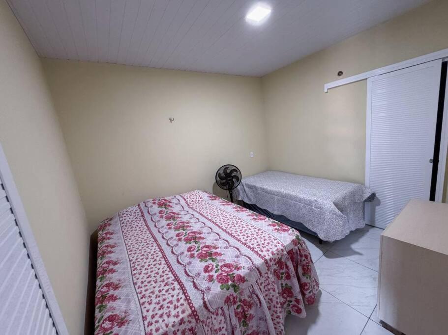 a bedroom with a bed with a red and white blanket at Apartamento em Mundaú in Trairi