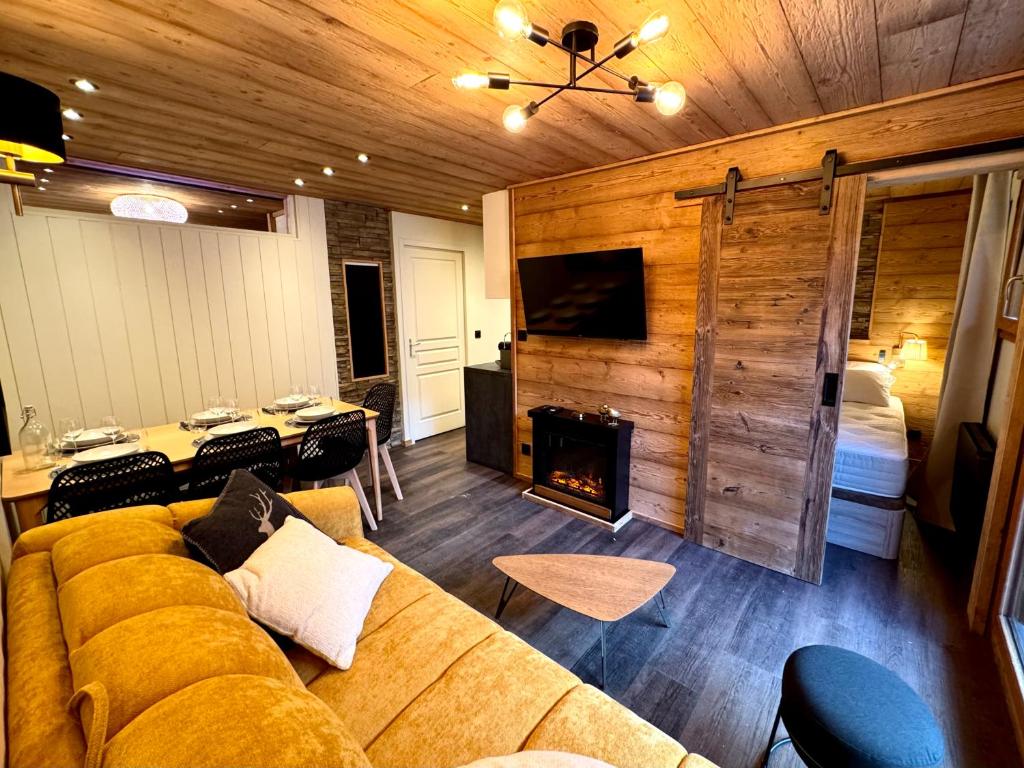 un salon avec un canapé et une cheminée dans l'établissement T3 Centre ORRES 1800 - 6 personnes sur piste - Rénové avec parking - M4, aux Orres