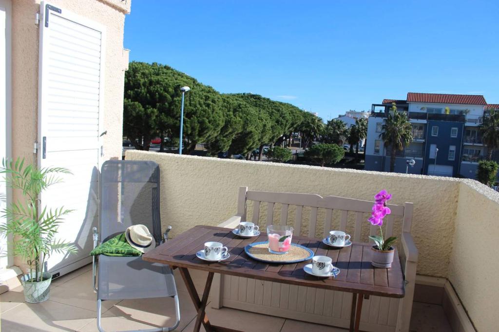 - une table sur un balcon avec un service à thé dans l'établissement Charmant T2 climatisé au cœur de Saint Cyprien plage - 4MIR23, à Saint Cyprien Plage