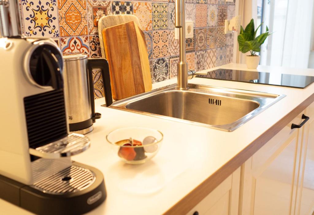 een aanrecht met een wastafel en een mixer bij Würzburg Studio mit Dachterrasse - Tiefgarage & Nähe Bahnhof in Würzburg