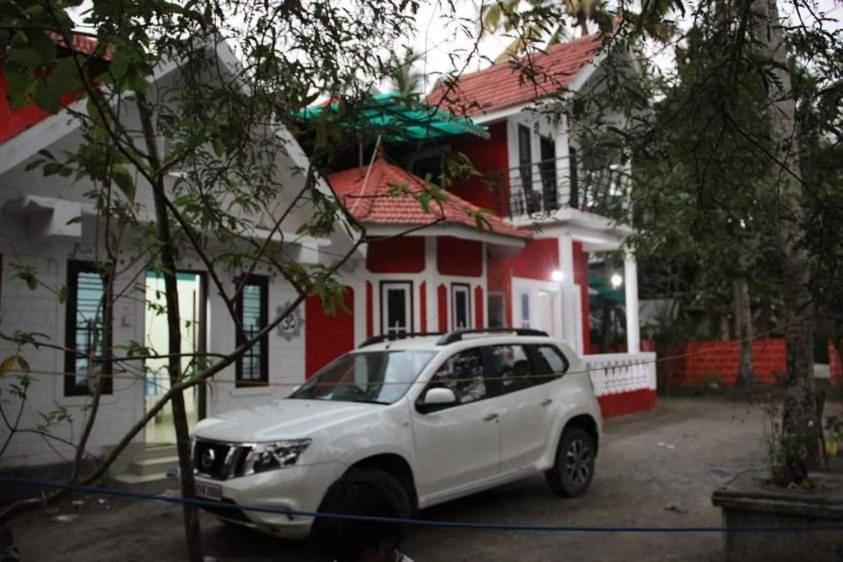a white car parked in front of a house at Emma Homestay in Pattiyūrgrāmam