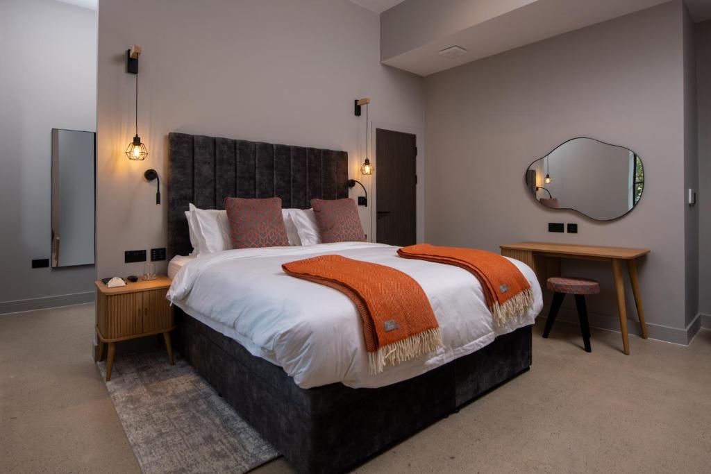a bedroom with a large bed and a large mirror at Montgomery House Apart-Hotel in Headingley