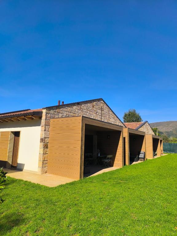 a house with a garage and a green lawn at Las Casitas de Cueva in Cueva