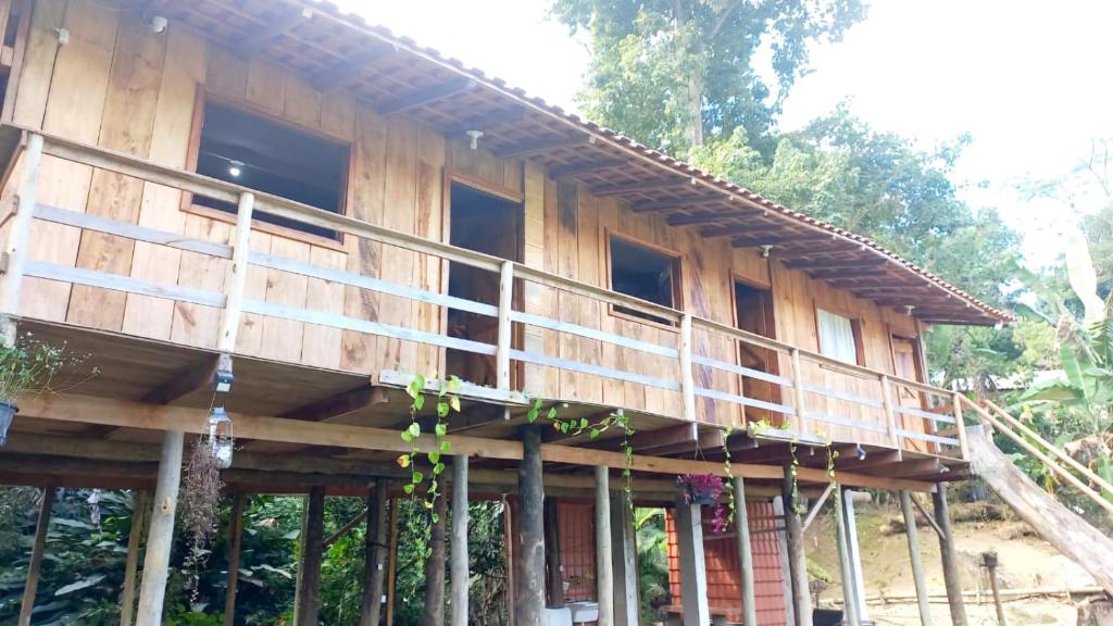 ein Holzhaus mit einem Balkon an der Seite in der Unterkunft Chalés Vitória in Trindade