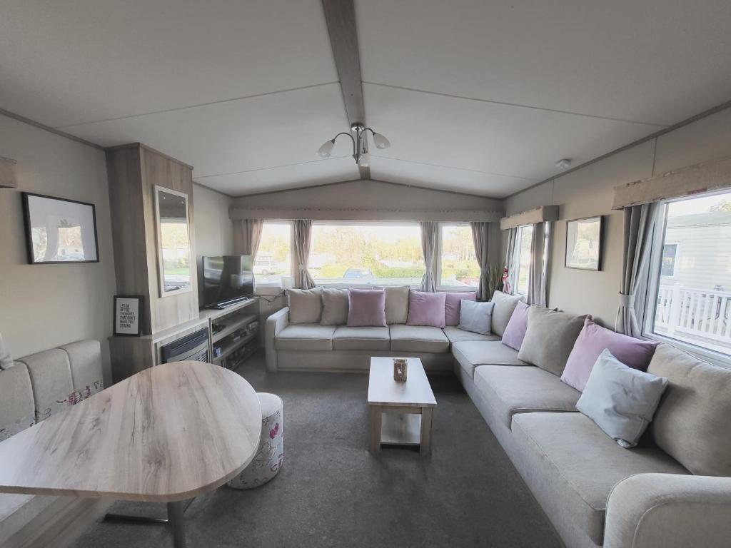 a living room with a couch and a table at Caravan under the tree in Port Seton